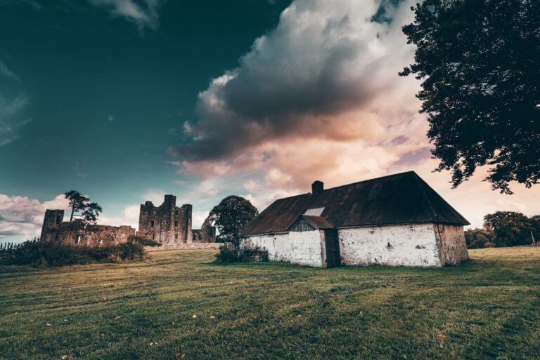 a house with a castle behind it Bective Abbey
