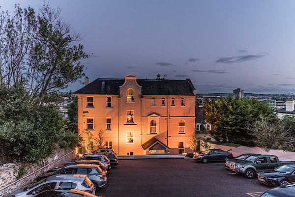 a large house with a light shining on it at night where to stay in Cork city