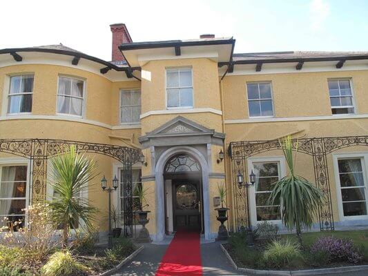 a large building with palm trees outside where to stay in Cork City