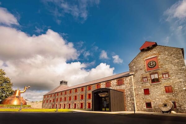 a large building with a copper pot still outside Midleteon Distillery Experience