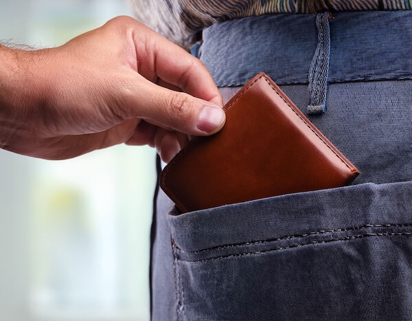 someone taking a wallet out of a back pocket top tips for solo travel to Ireland