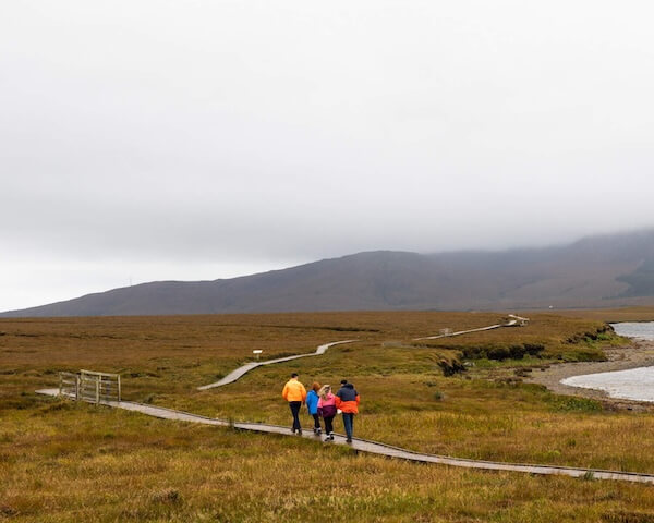 people walking on a boardwalk in the country visiting Ireland's national parks