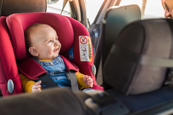 a baby in a car seat traveling to Ireland with young children