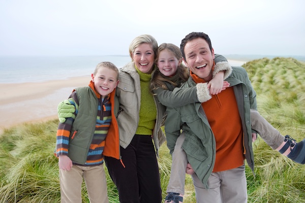 four people at the beach traveling to Ireland with young children