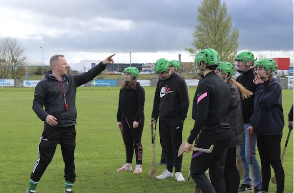 a man points in the distance while others listen Hurling Tours Ireland