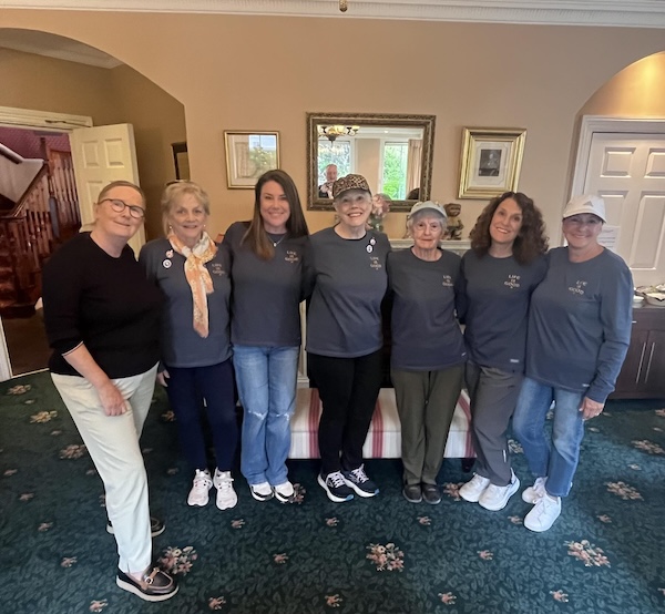 a group of people standing in a room Away to Ireland