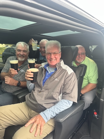 men sitting in a van drinking pints of Guinness the smarter way to see Ireland